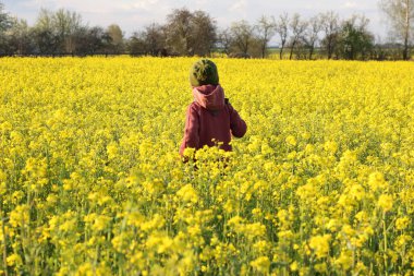 Arkadan çiçek açan tecavüz sahasında çocuk, kır evi çiftliği estetiği, temiz hava, kırsal bölge, yavaş yaşam, pastoral yaşam, açık hava terapisi konsepti.