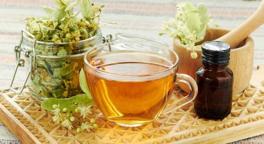 ıhlamur ağacı çiçekli ıhlamur çayı ve kırsal ahşap kesim tahtasında kurutulmuş bitki konservesi, arka ışıklandırma, yakın çekim, kopyalama alanı, alternatif tıp ve naturopati konsepti.