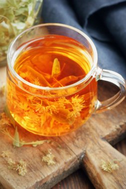 Ağaç kabında çiçekli ıhlamur çayı yakınlarda limon çiçeği, kuru ot, rahatlamak için yakın plan, zihinsel sağlık, naturopati, homeopati ve halk sağlığı konsepti.