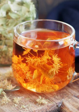 Ağaç kabında çiçekli ıhlamur çayı yakınlarda limon çiçeği, kuru ot, rahatlamak için yakın plan, zihinsel sağlık, naturopati, homeopati ve halk sağlığı konsepti.