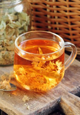 Ağaç kabında çiçekli ıhlamur çayı yakınlarda limon çiçeği, kuru ot, rahatlamak için yakın plan, zihinsel sağlık, naturopati, homeopati ve halk sağlığı konsepti.