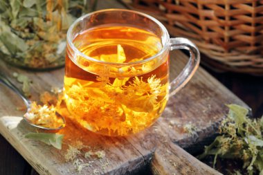 Ağaç kabında çiçekli ıhlamur çayı yakınlarda limon çiçeği, kuru ot, rahatlamak için yakın plan, zihinsel sağlık, naturopati, homeopati ve halk sağlığı konsepti.