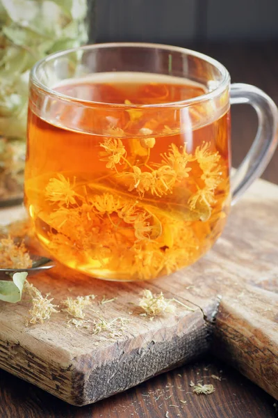 Herbata Ziołowa Lipy Kwiatami Szklanym Kubku Drewnianej Desce Rustykalnej Limonką — Zdjęcie stockowe