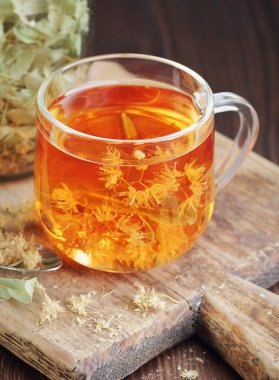 Ağaç kabında çiçekli ıhlamur çayı yakınlarda limon çiçeği, kuru ot, rahatlamak için yakın plan, zihinsel sağlık, naturopati, homeopati ve halk sağlığı konsepti.