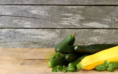 Taze bahar ve yaz sebzelerinin çeşitliliği: salatalık, fesleğen, kabak, kabak, kırsal ahşap arkaplan üzerine dereotu tasarım, yakın plan, organik eko ev yapımı gıda konsepti