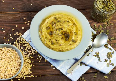 Lenten yiyecek: kabak ve keten tohumlarıyla süslenmiş kremalı bezelye lapası ya da çorba ahşap masa, yakın plan, yukarıdan bakıldığında kopyalama alanı. Hızlı yemek ve vejetaryen yemek konsepti.