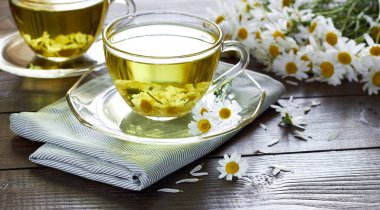 Papatya çayı, çiçek tomurcukları yakınlarda ahşap masa üzerinde tekstil ve papatya buketi, yakın plan, kopyalama alanı, sağlıklı bitkisel içecekler ve doğal şifacı konsepti.