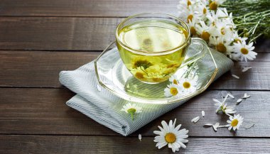 Papatya çayı, çiçek tomurcukları yakınlarda ahşap masa üzerinde tekstil ve papatya buketi, yakın plan, kopyalama alanı, sağlıklı bitkisel içecekler ve doğal şifacı konsepti.