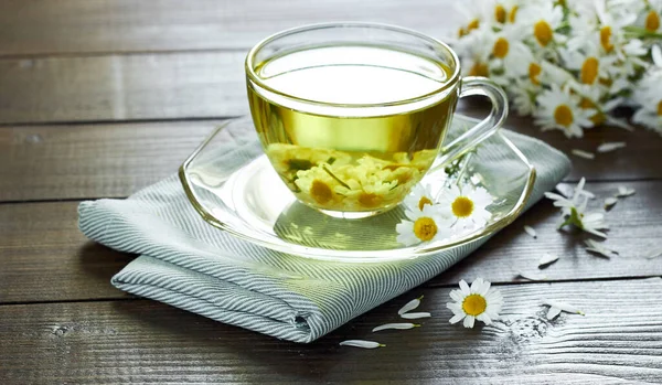 Papatya çayı, çiçek tomurcukları yakınlarda ahşap masa üzerinde tekstil ve papatya buketi, yakın plan, kopyalama alanı, sağlıklı bitkisel içecekler ve doğal şifacı konsepti.
