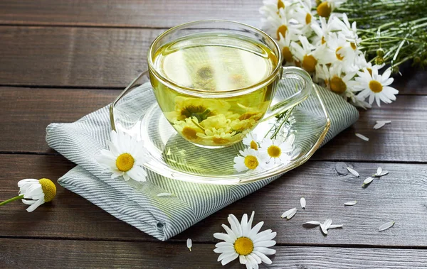 Papatya çayı, çiçek tomurcukları yakınlarda ahşap masa üzerinde tekstil ve papatya buketi, yakın plan, kopyalama alanı, sağlıklı bitkisel içecekler ve doğal şifacı konsepti.