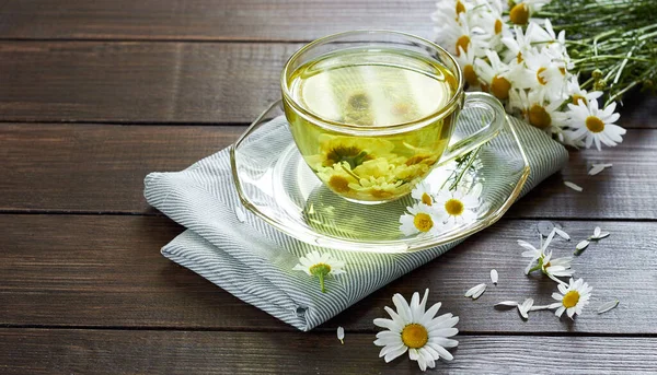 Papatya çayı, çiçek tomurcukları yakınlarda ahşap masa üzerinde tekstil ve papatya buketi, yakın plan, kopyalama alanı, sağlıklı bitkisel içecekler ve doğal şifacı konsepti.