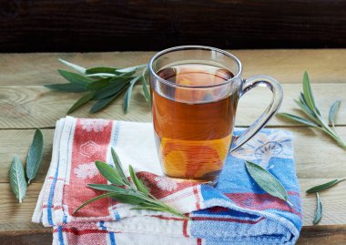 Kırmızı peçete ve ahşap masa, fotokopi alanı, alternatif tıp ve naturopati konsepti ile çevrili keten mavi yapraklı iki bardak bitkisel çay ya da decoction