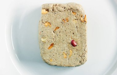 Bir parça ayçiçeği halva tatlı tatlı normal fıstık ve beyaz kaplama arka planda kırmızı kabuklu sıradışı bir kabuk düz, üst görünüm, yakın plan, kopyalama alanı