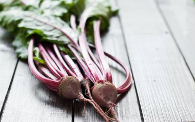 Kırmızı pancar kökü ilk mevsimlik hasat: Tahta masa üzerinde yaprakları olan taze taze sebzeler, yakın plan, kopyalama alanı, kendi tarım ve bahçe konseptinizi yetiştirin