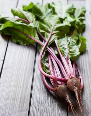 Kırmızı pancar kökü ilk mevsimlik hasat: Tahta masa üzerinde yaprakları olan taze taze sebzeler, genel görünüm, yakın çekim, kopyalama alanı, kendi yetiştirme, tarım ve bahçe konsepti