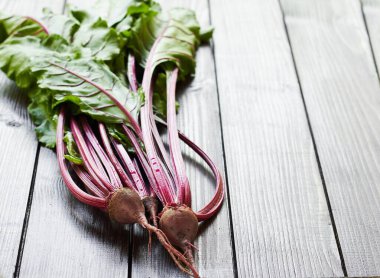 Kırmızı pancar kökü ilk mevsimlik hasat: Tahta masa üzerinde yaprakları olan taze taze sebzeler, genel görünüm, yakın çekim, kopyalama alanı, kendi yetiştirme, tarım ve bahçe konsepti