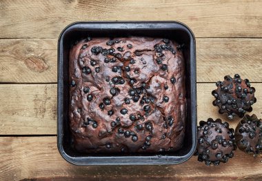 Çikolatalı yaban mersinli pasta, kapkekler kırsal ahşap masa, düz masa, yukarıdan bakıldığında, yakın çekim, fotokopi alanı, ev yapımı vejetaryen yumurtasız pasta konsepti
