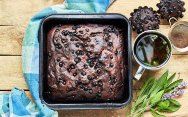 Kek ve otlu çikolatalı kek: Nane, lavanta, adaçayı yakınlarda ve kırsal ahşap masa üzerinde kekik çayı, düz konum, yukarıdan bakıldığında, kapalı, kopyalama alanı, ev yapımı yumurtasız tatlı konsepti