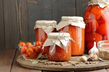 Konserve ev yapımı domates ezmesi ve salamura domates. Kilerdeki kırsal masada plastik kavanozlar, yakın çekim, pamuk helvası, basit yaşam estetiği, ev depolama çözümü, arta kalan yemekler, konserve, fermantasyon konsepti.