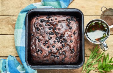 Çikolatalı kek, otlar: yakınlarda nane ve lavanta ve kırsal ahşap masa üzerinde bir fincan kekik çayı, düz, yukarıdan bakıldığında, yakın plan, fotokopi alanı, ev yapımı yumurtasız tatlı konsepti
