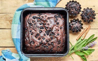 Kek ve otlu çikolatalı kek: yakınlarda kırsal ahşap masa üzerinde naneli, lavantalı, adaçayı ve tarçın, düz, yukarıdan bakıldığında, yakın plan, fotokopi alanı, ev yapımı, yumurtasız tatlı konsepti