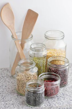 Kuru baklagillerin çeşitleri: böbrek fasulyesi, bezelye, cam kavanozlarda pişirilmemiş yeşil gram beyaz mutfak arka planı, sıfır atık, çevre dostu, dengeli diyet yiyecekler, sağlıklı temiz yiyecekler, vegan protein konsepti