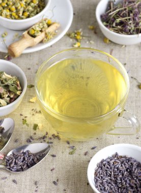 Cam fincanda papatya çayı ve kavanozda kuru bitki çiçekleri, yukarıdan bakıldığında doğal tıp, uyku için şifalı içecekler, cilt ve saç bakımı konsepti.