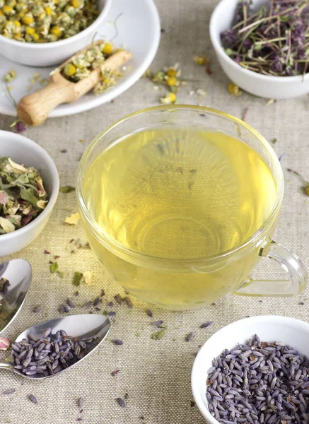 Cam fincanda papatya çayı ve kavanozda kuru bitki çiçekleri, yukarıdan bakıldığında doğal tıp, uyku için şifalı içecekler, cilt ve saç bakımı konsepti.