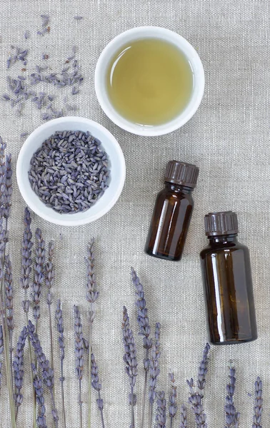 Lavender essential oil, dry herb in a bowl with flowers nearby, closeup, from above overhead top view, natural medicine, naturopathy, organic cosmetics, sleep tea, skin and hair care concept