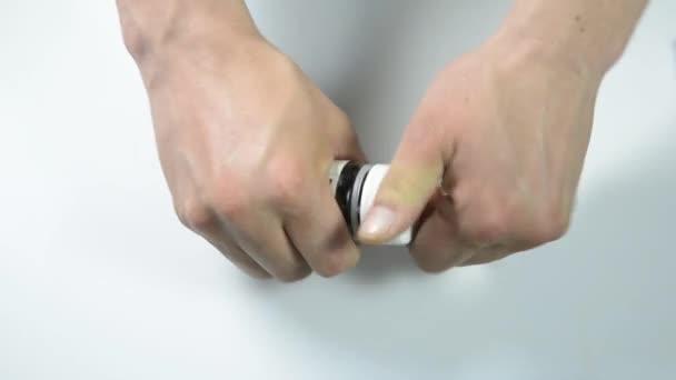 pilules médicales, vitamines priparaty à la main sur un fond blanc, disperser recueillir, enlever le pot, il recueille sur la table 