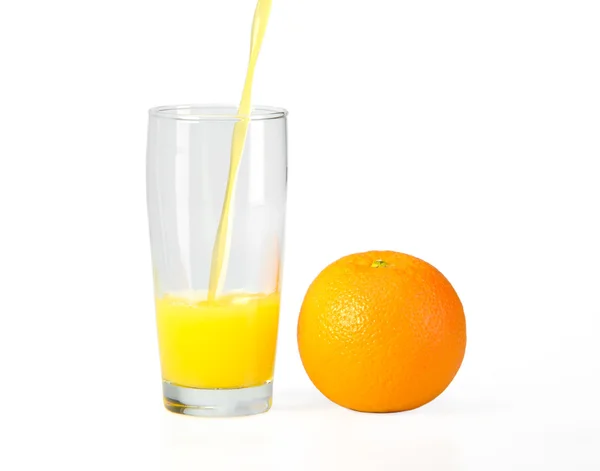 A glass of orange juice on a white background and orange — Stock Photo, Image