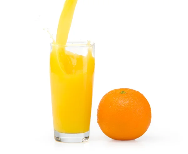 A glass of orange juice on a white background and orange — Stock Photo, Image