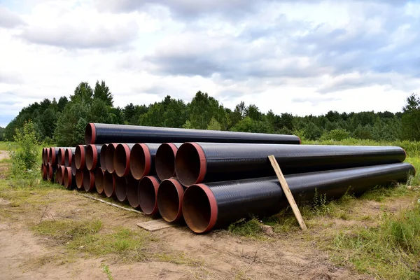 Crude oil and Natural gas pipeline construction work in forest area.  Petrochemical Pipe on top of wooden supports. Installation and Construction the Pipeline for transport gas to LNG plant