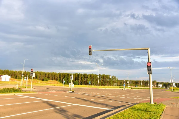 Red traffic signal at road. Traffic light control and coordination. Crosswalk at a city road intersection.  Traffic stops at intersection to let walkers cross in all four directions