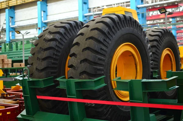 Warehouse with tires for trucks at an industrial plant for the production of cars. The protector of a large rubber wheel. Rubber tire from the tipper. MountingWarehouse with tires for trucks at an industrial plant for the production of cars. The prot