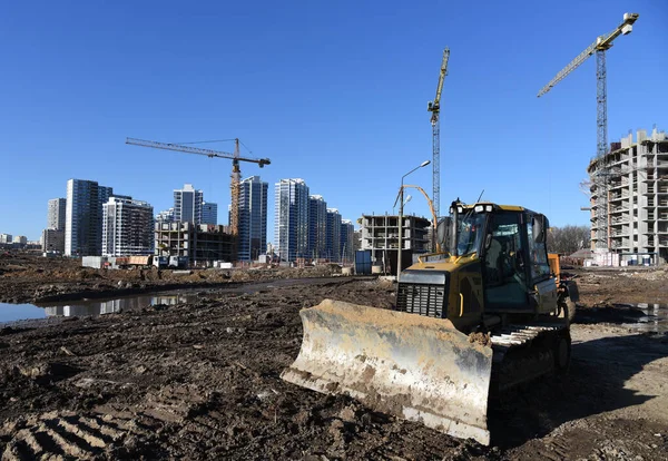 Dozer working at construction site. Bulldozer for land clearing, grading, pool excavation, utility trenching and foundation digging. Crawler tractor and earth-moving equipment