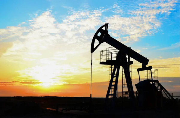 Oil drilling derricks at desert oilfield for fossil fuels output and crude oil production from the ground. Oil drill rig and pump jack.