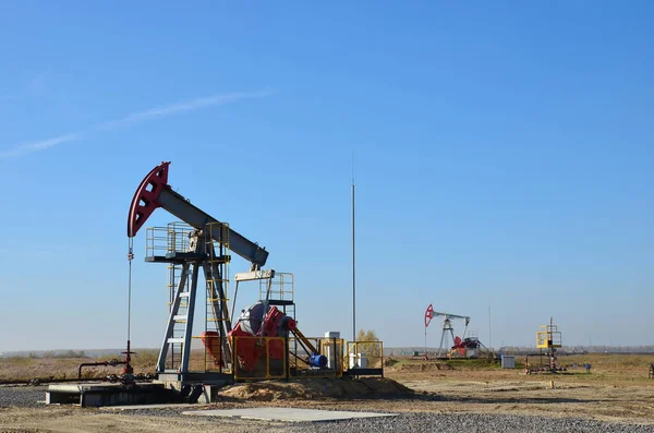 Oil drilling derricks at desert oilfield for fossil fuels output and crude oil production from the ground. Oil drill rig and pump jack.