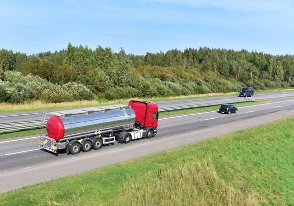 Tank truck transport of liquid, foodstuff. Metal chrome cistern tanker for food transportation on highway. Out of focus, possible granularity.