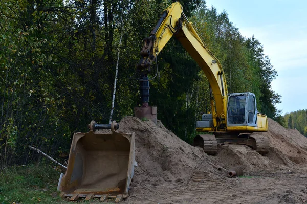 Excavator with Vertical tamrock pile foundation drilling machine. Drill rig at forest area. Ground Improvement techniques, vibroflotation probe. Vibro compaction method. Piling Contractors