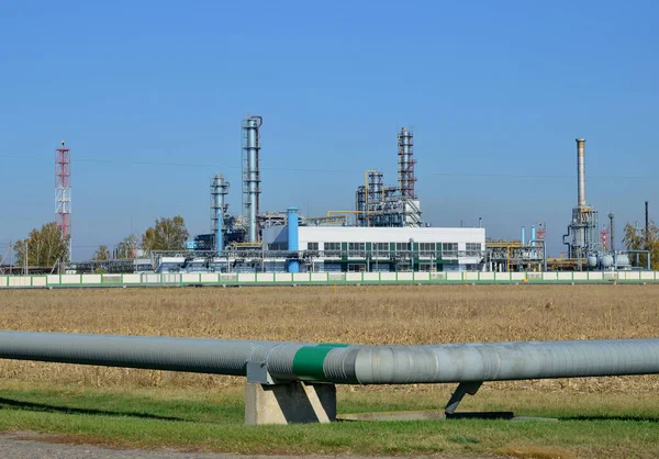 Gas Processing Plant. Power pipes and industrial refinery towers of natural gas factory on the background blue sky. Oil drill rig and drilling derrick. Global crude oil Prices, energy, petroleum demand