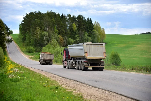 Truck with tipper semi trailer transported sand from the quarry on driving along highway. Modern Dump Semi-Trailer Rear Tipper Truck Trailer