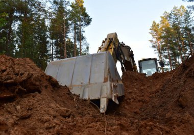 Kazıcı yeni gelişmeler ve yol çalışmaları için ormanı temizliyor. Orman işleri için kepçe. Orman ve turba endüstrisi için ağır güç makinelerinin izini sürdüm. Ağaç kesme, ormanlarda yol yapımı
