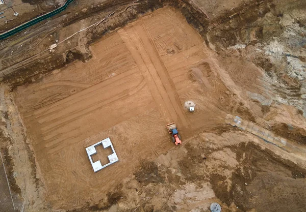 Drone view of the construction site. Vibration road roller leveling the ground for the construct of the foundation for residential building. Soil Compactor compresses the soil under the formwork