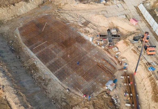 Aerial view of a onstruction site with foundation pit for monolithic reinforced skyscraper. Monolithic slab foundation and concrete pouring. First floor slab rebar installation