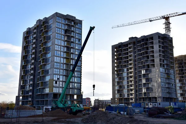 Mobile auto crane at construction site. Work of truck crane on project works. Tower cranes and builders in action. Crane for building multi-story a home