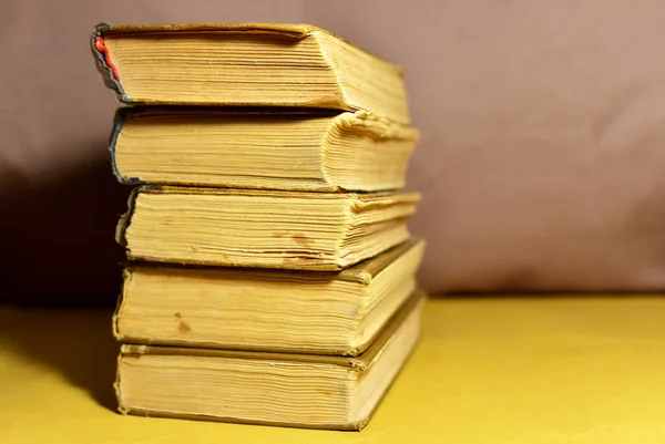 Old books on brown background. Book for reading stories. Literature and historical concept, nostalgia, old age. Retro background.