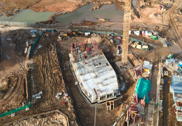 Construction site with foundation pit for monolithic reinforced skyscraper. Monolithic slab foundation and concrete pouring. First floor slab rebar installation. Tower crane on building construction.