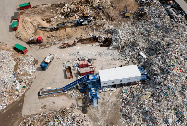 Landfill for the recycling of construction waste and dispose debris. Industrial rubbish treatment processing factory. Garbage dump with plastic bags and food waste. Trash disposal at junk yard.