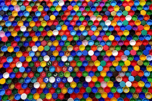 Plastic bottle caps background. Cap material is recyclable.Remove lids from plastic bottles before recycling them. Recycling collection and processing plastic bottle caps